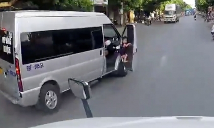 Clip TNGT: Hoảng hồn nhìn cậu bé treo mình trên cánh cửa xe chở học sinh đang sang đường